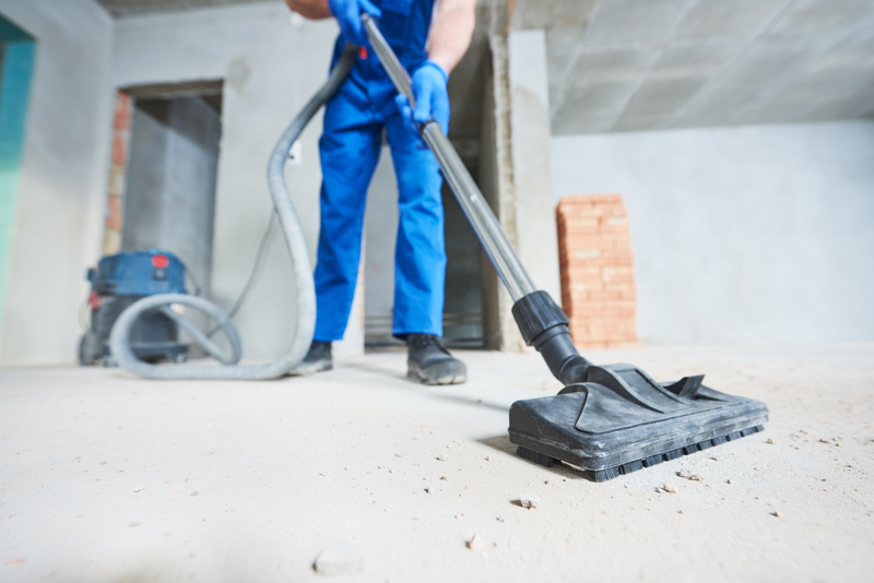 Man vacuuming dust in a newly constructed building